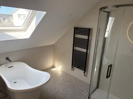 A bathroom with a bathtub and shower at Seaddler in Trearddur Bay