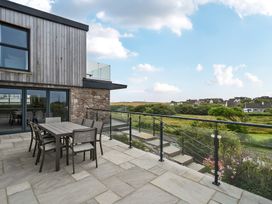 An outdoor patio area with a table and chairs at Seaddler in Trearddur Bay