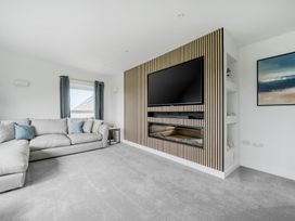 A living room with a sofa and television at Seaddler in Trearddur Bay
