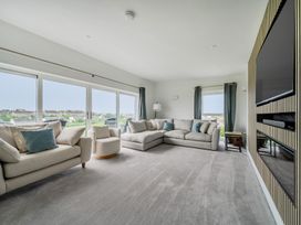 A living room with sofa and television at Seaddler in Trearddur Bay