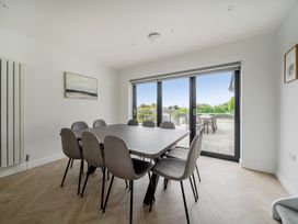 A dining room with a table and chairs at Seaddler in Trearddur Bay
