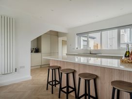 A kitchen with a large island and bar stools at Seaddler Trearddur Bay