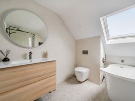 A bathroom with a bathtub and vanity at Seaddler in Trearddur Bay
