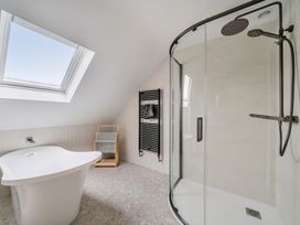A bathroom with a bathtub and shower at Seaddler in Trearddur Bay