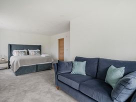 A bedroom with a bed and sofa at Seaddler in Trearddur Bay