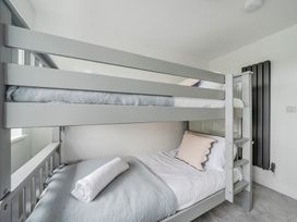 A bunk bed with bedding in a bedroom at Seaddler in Trearddur Bay