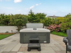 A garden with a hot tub and steps at Seaddler in Trearddur Bay