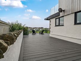 An outdoor deck with chairs and plants at Seaddler in Trearddur Bay
