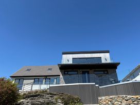A house with a balcony and stone wall at Seaddler in Trearddur Bay