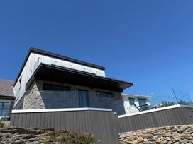 A house with a balcony and stone features at Seaddler in Trearddur Bay