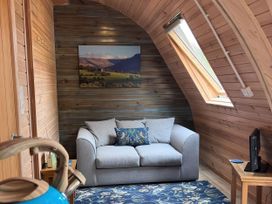 A living room with a sofa and painting at Lakeside Pods - pet free in Greenfield