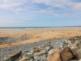 A sandy beach with people and a rocky shoreline at Hartland Quay near Hartland