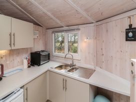 A kitchen with a double sink stove and toaster oven with wooden walls and ceiling at Shipload Bay near Hartland