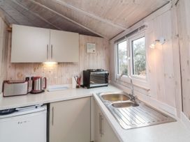 A compact kitchen with a sink a toaster kettle mini oven cabinets and a window at Shipload Bay near Hartland