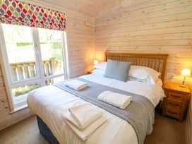 A bedroom with a double bed and a bedside table at Dovestone Luxury Lodges (sleeps 4)- pet free Greenfield