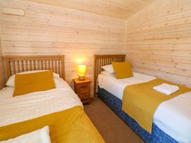 A bedroom with two single beds at Dovestone Luxury Lodges (sleeps 4)- pet free in Greenfield