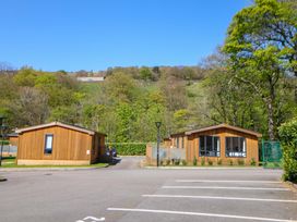 Two wooden lodges in an outdoor setting at Dovestone Luxury Lodges (sleeps 4)- pet free in Greenfield