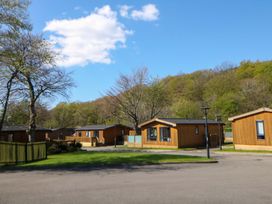 An outdoor area with wooden cabins at Dovestone Luxury Lodges (sleeps 4)- pet free, Greenfield