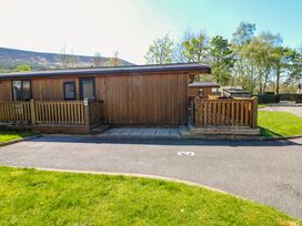 A wooden lodge with a deck and pathway at Dovestone Luxury Lodges (sleeps 4) - pets welcome in Greenfield