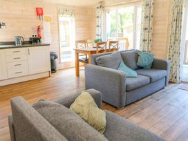 A living room with a kitchen unit and sofas at Dovestone Luxury Lodges (sleeps 4) - pets welcome, Greenfield