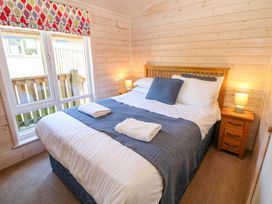 A bedroom with a bed and a bedside table at Dovestone Luxury Lodges (sleeps 4) - pets welcome in Greenfield