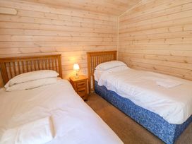 A bedroom with two beds and a nightstand at Dovestone Luxury Lodges (sleeps 4) - pets welcome Greenfield