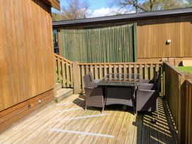 An outdoor seating area with a table and chairs at Dovestone Luxury Lodges (sleeps 4) - pets welcome Greenfield