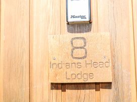 A door with a wooden sign displaying the number 8 and the name Indians Head Lodge