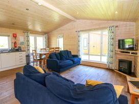 A living room with a couch and dining table at Dovestone Luxury Lodges (sleeps 6) - pet free, Greenfield