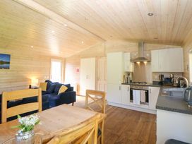 A living room with a sofa and kitchen units at Dovestone Luxury Lodges (sleeps 6) - pet free, Greenfield
