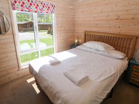 A bedroom with a bed and window at Dovestone Luxury Lodges (sleeps 6) - pet free, Greenfield