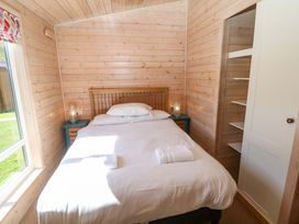 A bedroom with a bed and nightstand at Dovestone Luxury Lodges (sleeps 6) - pet free Greenfield