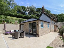 An outdoor seating area with a table and chairs at Upper Cottage Rocombe near Uplyme