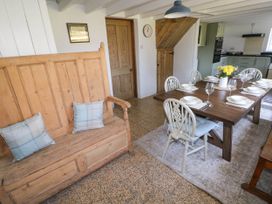 A dining area with a wooden bench and a table set with plates and glasses at Llanwern Farm in Fishguard