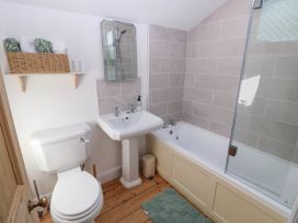 A bathroom with a toilet sink and bathtub with a glass shower screen at Llanwern Farm in Fishguard