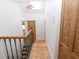A hallway with wooden doors and wooden floorboards at Llanwern Farm in Fishguard