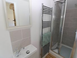 A bathroom with a sink mirror towel rack and a shower at Llanwern Farm in Fishguard