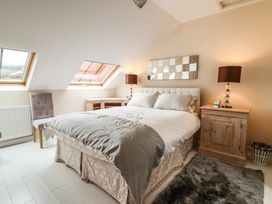 A bedroom with a double bed nightstand lamps and skylight windows at Cob Barn in Aylesbeare