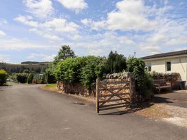 An outdoor area with a wooden gate and stone wall at Stable Cottage near Cottonshopeburnfoot