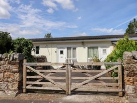 A house with a wooden gate and stone wall at Stable Cottage in Cottonshopeburnfoot near Otterburn