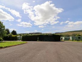 An outdoor view of caravans and grass at Fir Tree Cottage Cottonshopeburnfoot near Otterburn