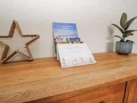 A wooden surface with a guest book and a holiday guide at Daisy Cottage in Wigton