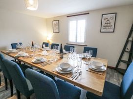 A dining room with a table set for dinner at Daisy Cottage in Wigton