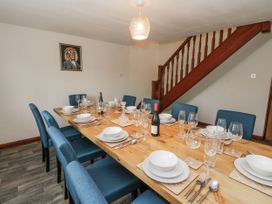 A dining room with a large table set at Daisy Cottage in Wigton