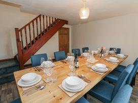A dining room with a large table set for dinner at Daisy Cottage in Wigton