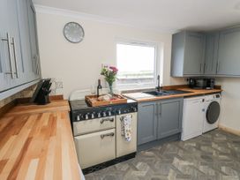 A kitchen with a cooker and sink at Daisy Cottage in Wigton