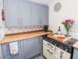 A kitchen with cabinets and utensils at Daisy Cottage in Wigton