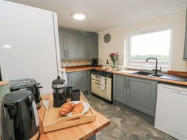 A kitchen with appliances and croissants on a countertop at Daisy Cottage in Wigton