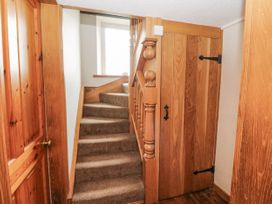 A hallway with stairs and a door at Daisy Cottage in Wigton