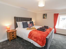 A bedroom with a bed and bedside table at Daisy Cottage in Wigton